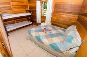 a bedroom with a bed in a wooden cabin at Chalés da Sinhá in Penha