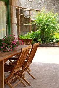 a wooden table and chairs with flowers on it at A Casa Di Mìnola in Roe
