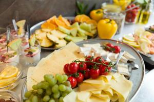 a table topped with cheese and tomatoes and grapes at Hotel Allén - Sure Hotel by Best Western Allen in Gothenburg +30 photos