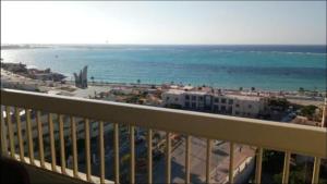 a balcony with a view of the beach and the ocean at Al-Madina Tower Apartments in Marsa Matruh