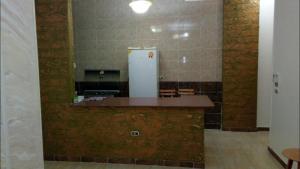 a kitchen with a counter with a refrigerator at Al-Madina Tower Apartments in Marsa Matruh