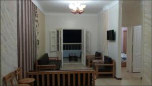 a living room with a couch and chairs and a television at Al-Madina Tower Apartments in Marsa Matruh