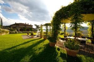 a garden area with green grass and a bench at Capannelle Wine Resort in Gaiole in Chianti