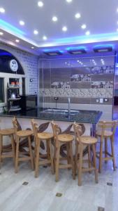 a kitchen with a bar with wooden chairs around it at Al-Madina Tower Apartments in Marsa Matruh