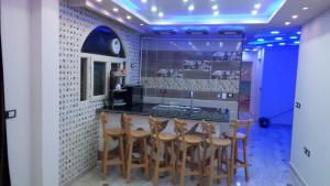 a kitchen with a bar with wooden stools at Al-Madina Tower Apartments in Marsa Matruh
