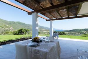 uma mesa num pátio com vista para as montanhas em Villa Dama luxury em Alghero