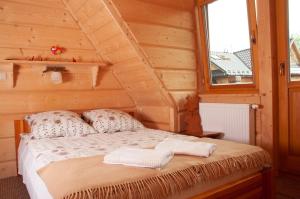 a bed in a wooden room with a window at Willa Pod Nosalem I in Zakopane