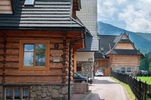 a log cabin with a car parked in front of it at Willa Pod Nosalem I in Zakopane