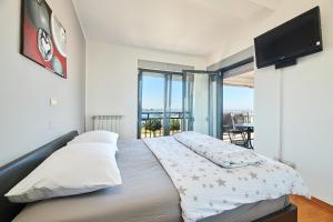 Schlafzimmer mit einem großen Bett und einem Flachbild-TV in der Unterkunft Apartment Bellavista Sea View in Umag