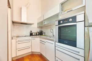 eine Küche mit weißen Schränken und einem Herd in der Unterkunft Apartment Bellavista Sea View in Umag