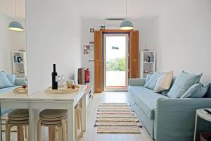 a living room with a blue couch and a table at Mood Lodging - Caldas & Ocean in Óbidos