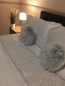 a bed with white pillows and two fuzzy pillows at Terra Nova Hotel in Aberdeen