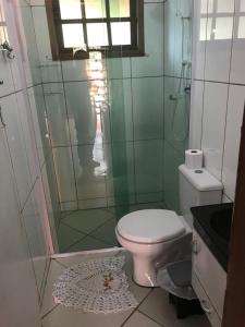 a bathroom with a toilet and a glass shower at Chalé da Lu in Santo Antônio do Pinhal