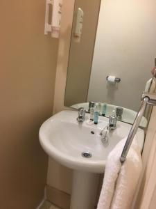 a bathroom with a white sink and a mirror at Terra Nova Hotel in Aberdeen