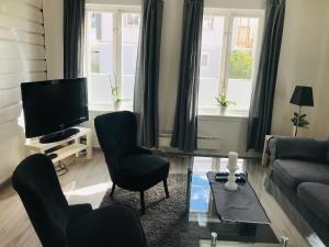 a living room with two chairs and a television at A Noi Rooms in Kragerø