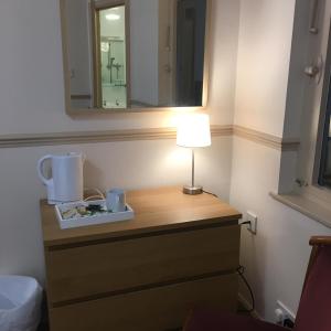 a table with a lamp and a mirror in a room at Terra Nova Hotel in Aberdeen