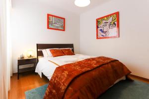 リスボンにあるAmazing Downtown Family Apartmentのベッドルーム1室(ベッド1台、ナイトスタンド、ベッドカバー付)