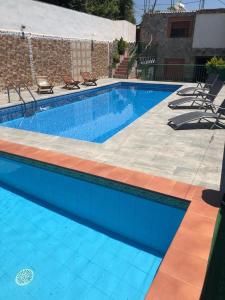 - une piscine avec 2 chaises à côté d'un bâtiment dans l'établissement El Aguacate, à Lanjarón