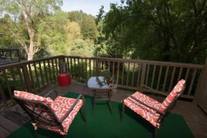 a deck with two chairs and a table and a table at River View Garden Resort in Monte Rio