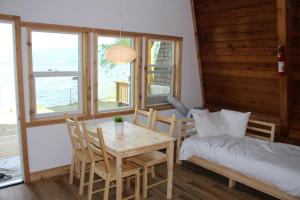 Cette chambre comprend une table, un lit, une table et des chaises. dans l'établissement Jewel Bay Resort, à Sorrento