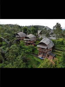 een groep huizen op een heuvel met bomen bij Bali Eco Village in Plaga