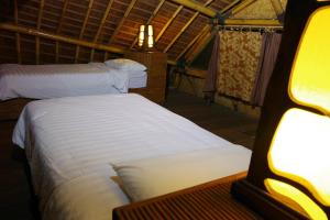 een slaapkamer met 2 bedden in een tent bij Bali Eco Village in Plaga