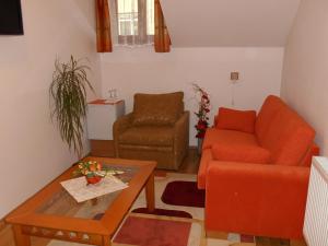 a living room with an orange couch and a table at Penzión Pars in Žilina