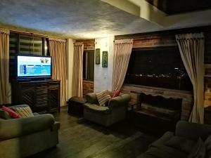sala de estar con chimenea y TV en Posada San Esteban, en Sutamarchán