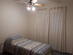 1 dormitorio con 1 cama y ventilador de techo en Sierras de La Punta en La Punta