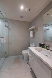 a bathroom with a toilet and a sink and a shower at Citadines Millennium Ortigas Manila in Manila