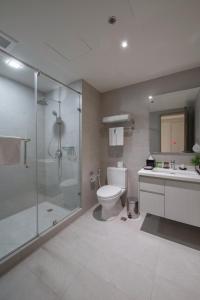 a bathroom with a shower and a toilet and a sink at Citadines Millennium Ortigas Manila in Manila