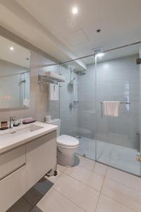 a bathroom with a toilet and a glass shower at Citadines Millennium Ortigas Manila in Manila