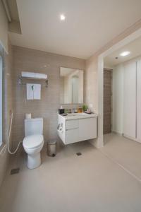 a bathroom with a white toilet and a sink at Citadines Millennium Ortigas Manila in Manila