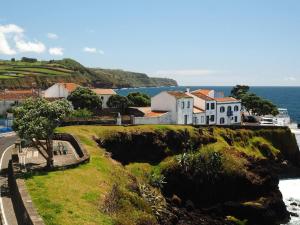 a house on a cliff next to the ocean at La Dolce Vita in Lagoa
