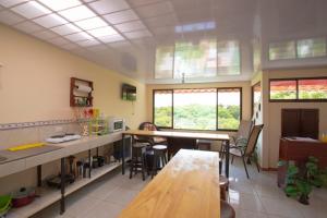 una cocina con mesas y sillas en una habitación en Flor de Katty Hostel Airport en Alajuela