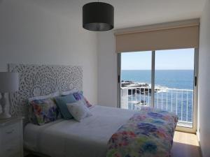 a bedroom with a bed with a view of the ocean at La Dolce Vita in Lagoa