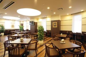 a restaurant with tables and chairs in a room at Hotel Route-Inn Kanda Ekimae in Kanda