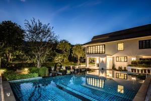 a swimming pool in the backyard of a house at Merchant Villa- SHA Extra Plus in Chiang Mai