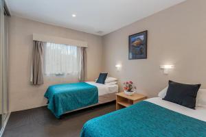 a hotel room with two beds and a window at Bay View Villas in Hobart