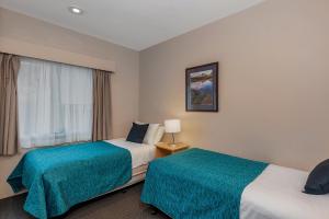a hotel room with two beds and two lamps at Bay View Villas in Hobart