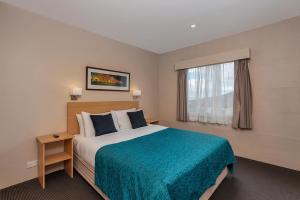 a hotel room with a bed and a window at Bay View Villas in Hobart