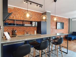 a kitchen with a bar with chairs and a brick wall at Ruska61 Apart in Wrocław