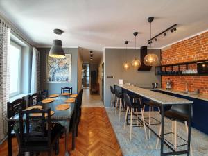 a kitchen with a table and a bar with stools at Ruska61 Apart in Wrocław