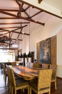 a dining room with a large wooden table and chairs at Lakeview Lodge Ngapali in Ngapali