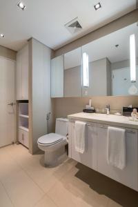 a bathroom with a toilet and a sink at Citadines Salcedo Makati in Manila