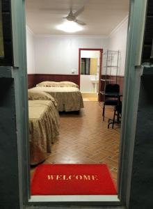 a hotel room with two beds and a welcome mat at The Village Backpackers in Nuku‘alofa