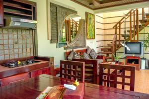 salon ze stołem, krzesłami i telewizorem w obiekcie The Bali Dream Villa Seminyak w mieście Seminyak