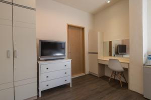 um quarto com uma televisão numa cómoda com uma secretária em CT House em Hualien