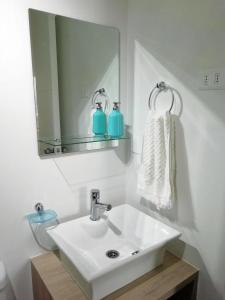 a bathroom with a white sink and a mirror at Moderno departamento, inmejorable vista al mar in Los Molles