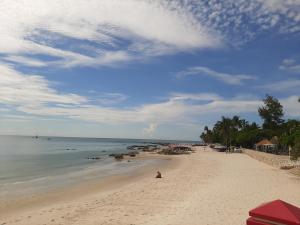a beach with a person sitting on the sand at Plaza Huahin in Hua Hin